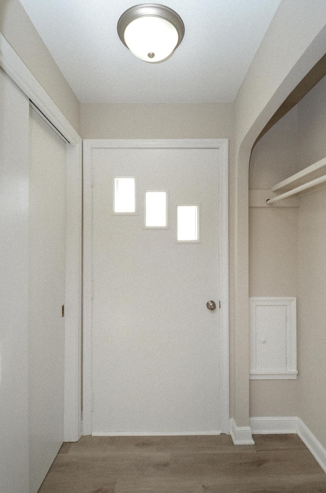 hallway featuring baseboards and wood finished floors