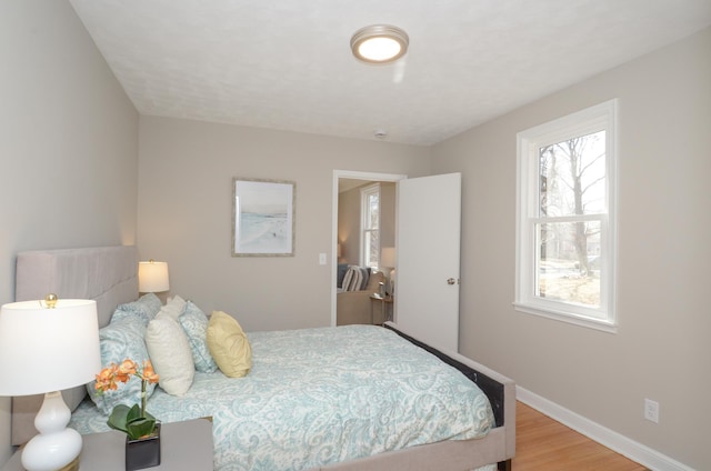 bedroom featuring baseboards and wood finished floors