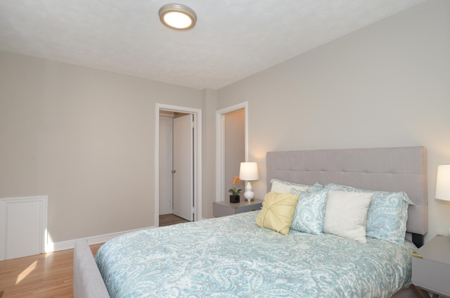 bedroom with baseboards and wood finished floors