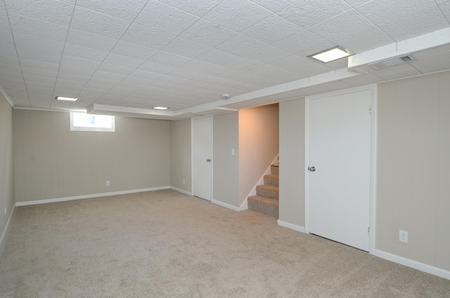 below grade area with stairway, visible vents, baseboards, and carpet