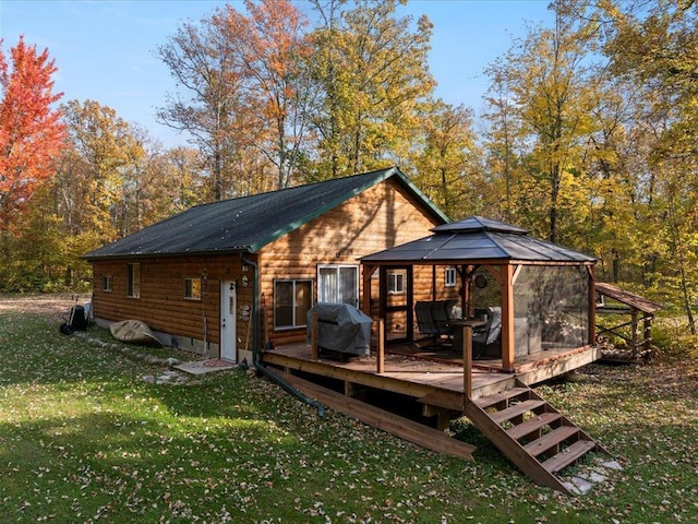 rear view of house with a gazebo, a lawn, and a deck