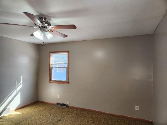 empty room featuring carpet flooring, a ceiling fan, visible vents, and baseboards