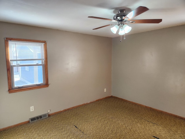 carpeted empty room featuring visible vents, baseboards, and a ceiling fan