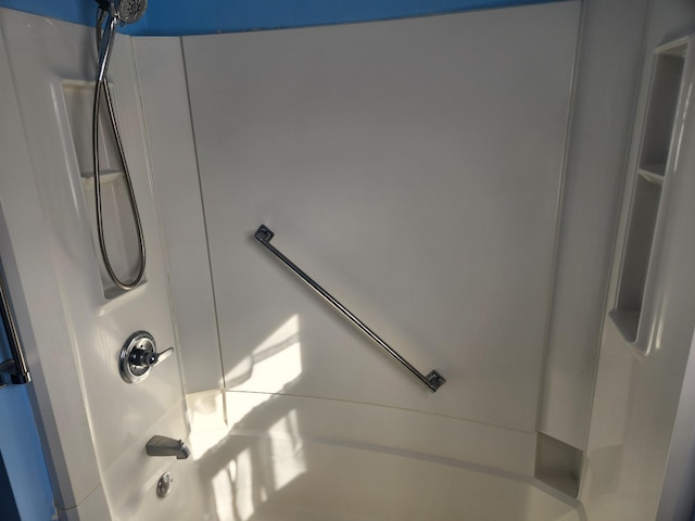 interior details featuring washtub / shower combination