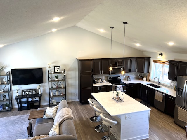 kitchen with wood finished floors, stainless steel appliances, light countertops, and a sink