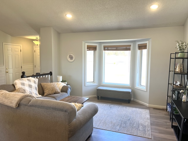 living room with recessed lighting, baseboards, dark wood-type flooring, and a textured ceiling
