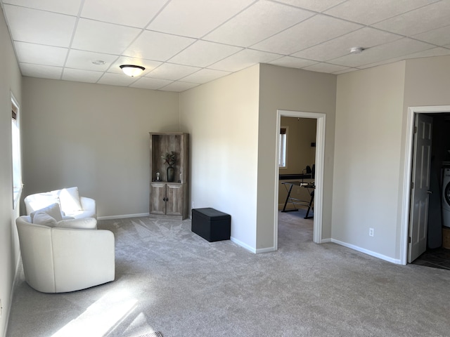 unfurnished room with a drop ceiling, carpet floors, baseboards, and washer / clothes dryer
