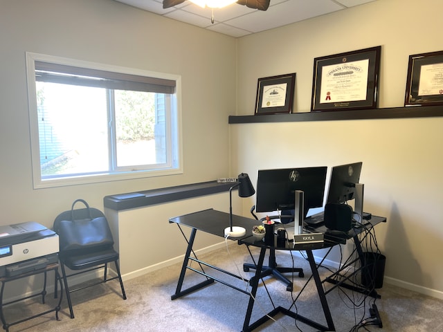 carpeted office featuring a drop ceiling, baseboards, and a ceiling fan