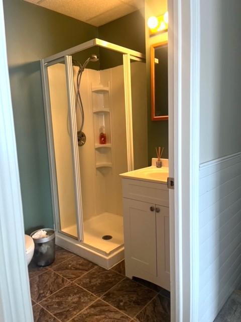 full bathroom with a shower stall, toilet, and vanity