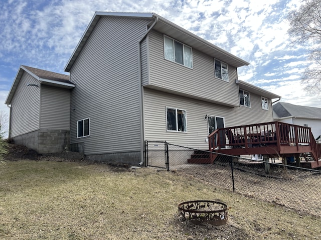 back of house featuring an outdoor fire pit, a deck, and fence