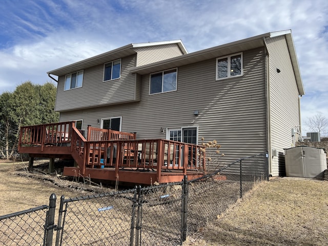 back of house with a fenced backyard, a deck, and a gate