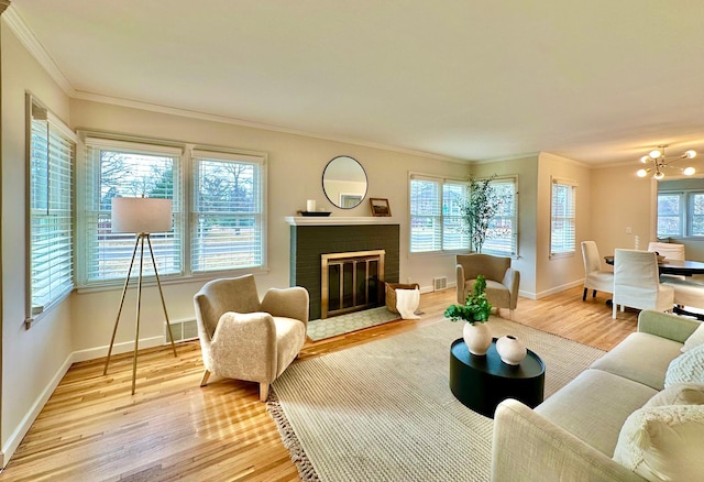 living area featuring a brick fireplace, wood finished floors, and ornamental molding