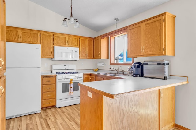 kitchen with white appliances, vaulted ceiling, a peninsula, light countertops, and a sink
