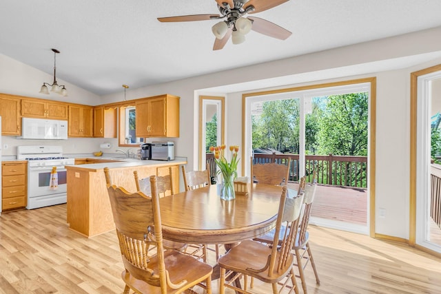 dining area featuring light wood-style flooring, plenty of natural light, lofted ceiling, and a ceiling fan