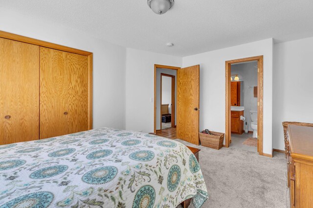 bedroom with light carpet, a closet, and ensuite bathroom