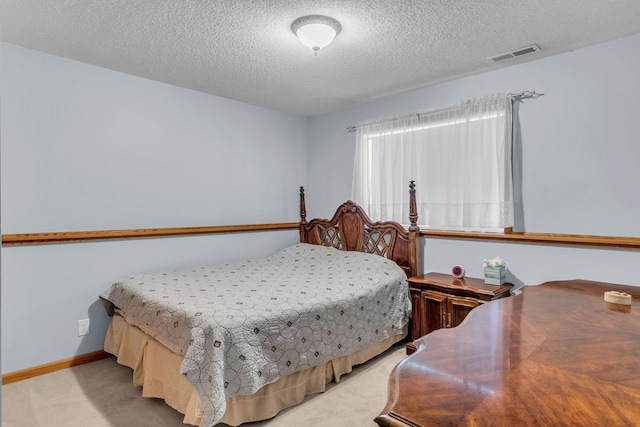 bedroom featuring a textured ceiling, light colored carpet, and baseboards