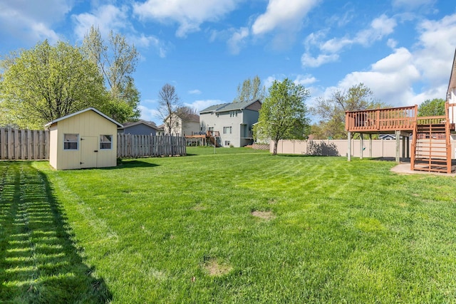 view of yard featuring a storage shed, a deck, an outbuilding, and stairs