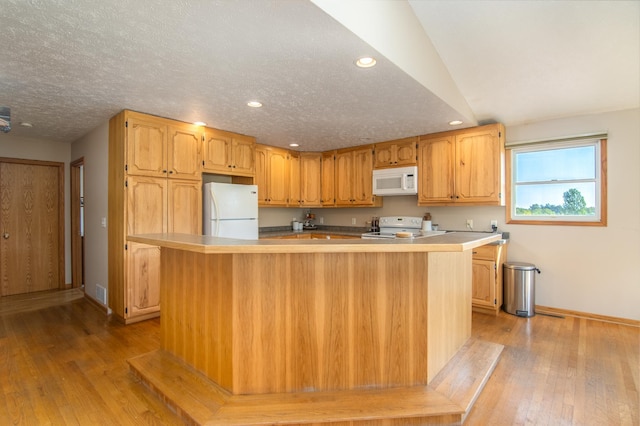 kitchen with recessed lighting, white appliances, light wood-style floors, and a textured ceiling