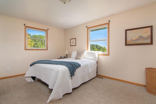 bedroom featuring baseboards and light colored carpet