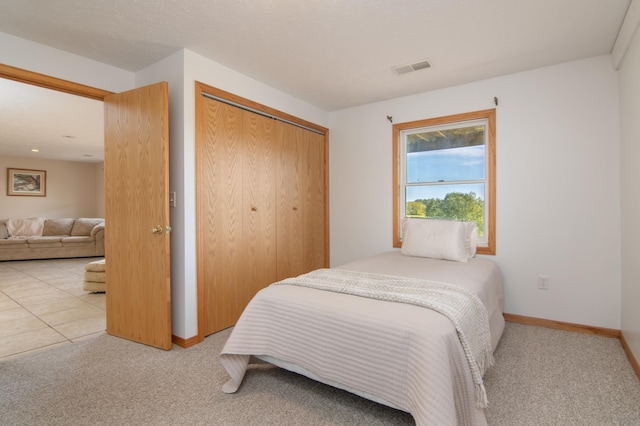 bedroom featuring baseboards, a closet, carpet floors, and visible vents