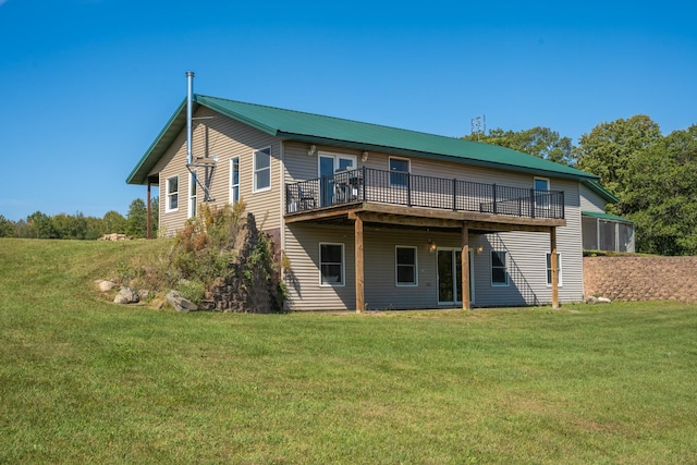 back of house featuring a deck, metal roof, and a yard