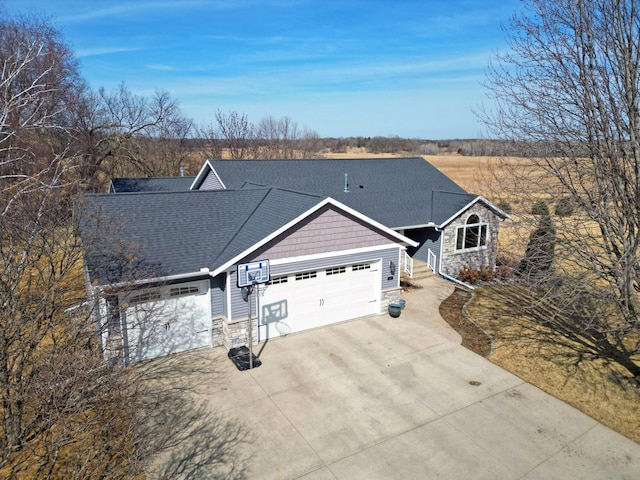 view of front of property featuring a garage, stone siding, roof with shingles, and driveway