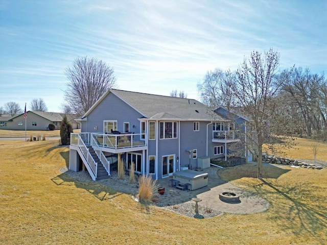 rear view of property featuring a fire pit, a wooden deck, stairs, a yard, and a patio area