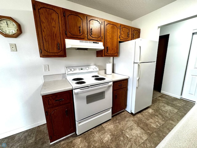 kitchen with white appliances, baseboards, light countertops, under cabinet range hood, and a textured ceiling