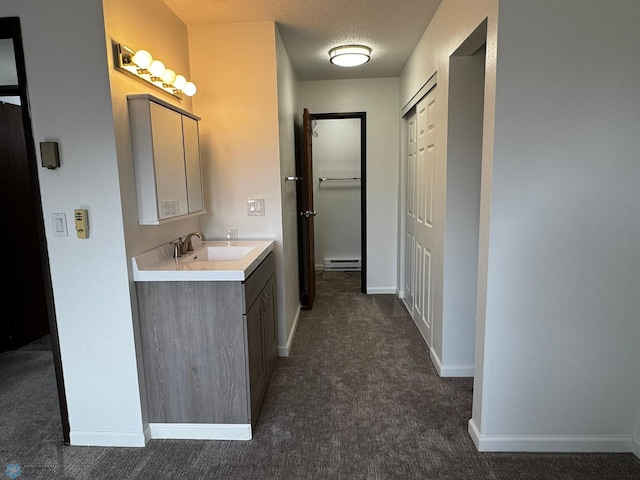 bathroom featuring vanity, a textured ceiling, baseboards, and a baseboard radiator