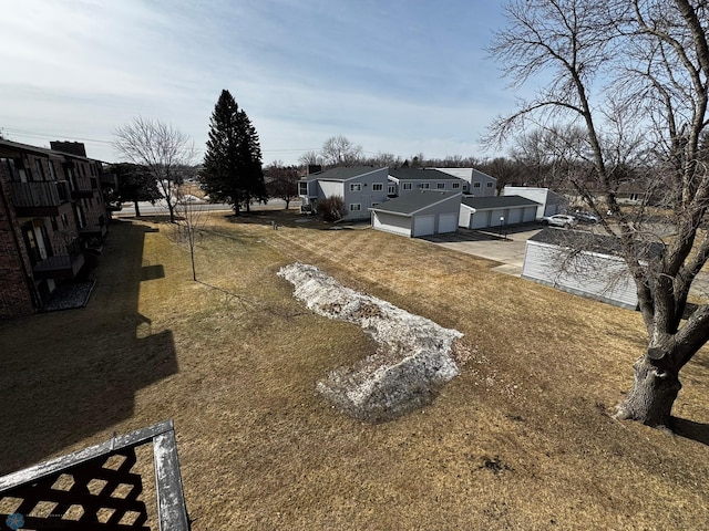 view of yard featuring a residential view and a garage