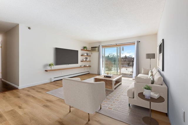 living area with a textured ceiling, wood finished floors, a wall unit AC, a baseboard radiator, and baseboards