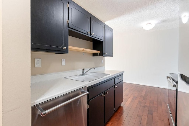 kitchen with dark wood-style flooring, a sink, light countertops, a textured ceiling, and dishwasher