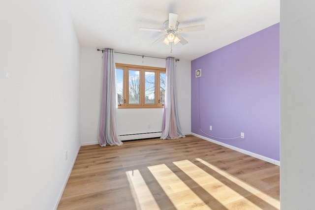 empty room with a ceiling fan, wood finished floors, baseboards, and a baseboard radiator