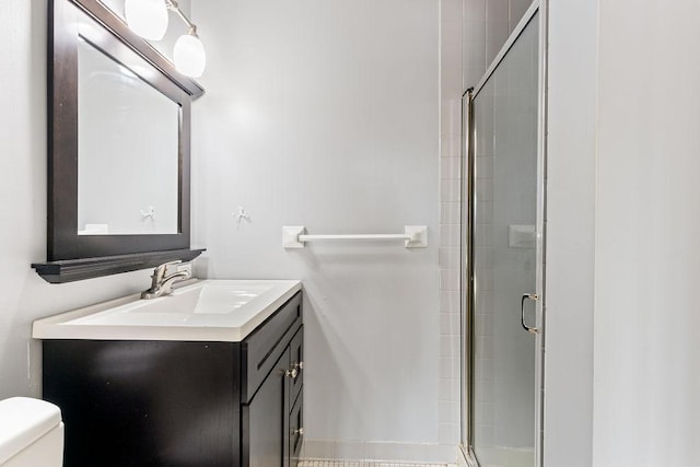 full bathroom featuring a stall shower, toilet, and vanity