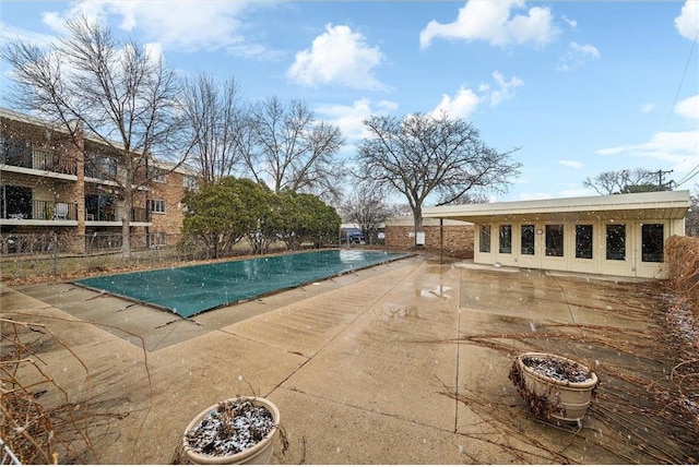 community pool with a patio and fence