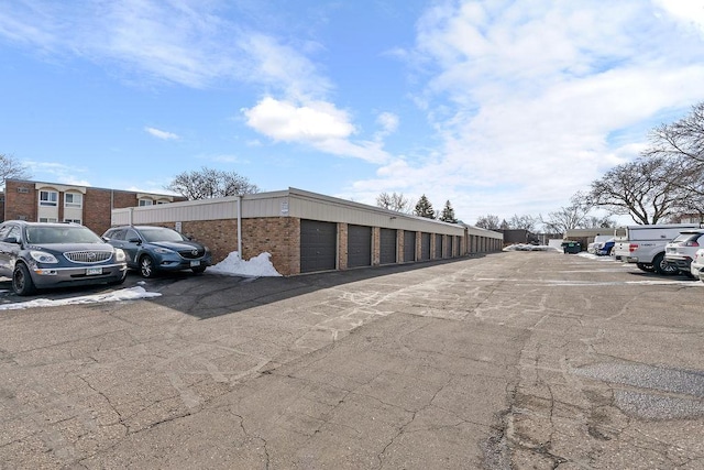 view of parking / parking lot featuring community garages