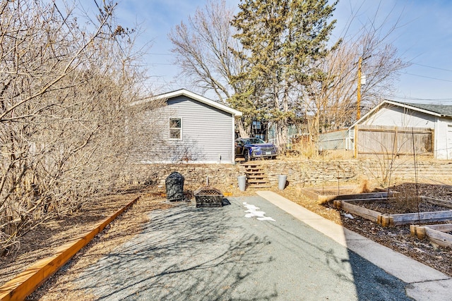 exterior space featuring a fire pit, a vegetable garden, and fence