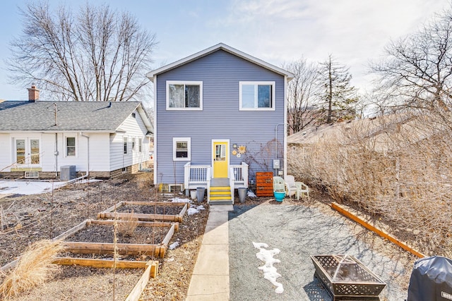 back of property featuring a garden, french doors, central AC unit, and an outdoor fire pit