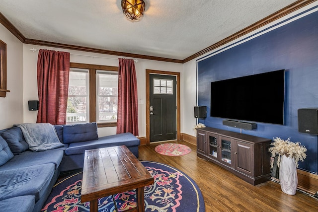 living area with crown molding, wood finished floors, baseboards, and a textured ceiling