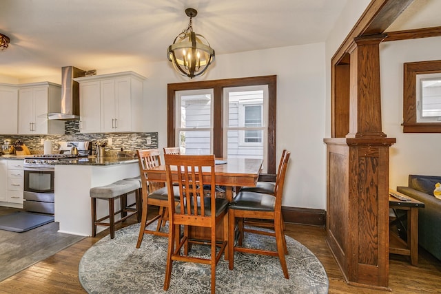 dining space featuring baseboards, a notable chandelier, and dark wood-style flooring