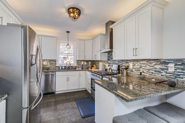 kitchen featuring a sink, tasteful backsplash, stainless steel appliances, a peninsula, and wall chimney range hood