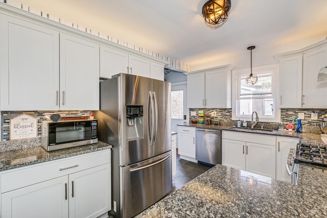 kitchen featuring tasteful backsplash, appliances with stainless steel finishes, white cabinetry, and a sink