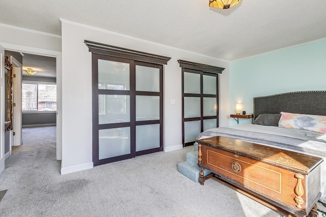 carpeted bedroom featuring baseboards, a textured ceiling, and crown molding