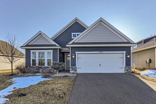 craftsman inspired home featuring board and batten siding, aphalt driveway, an attached garage, and stone siding