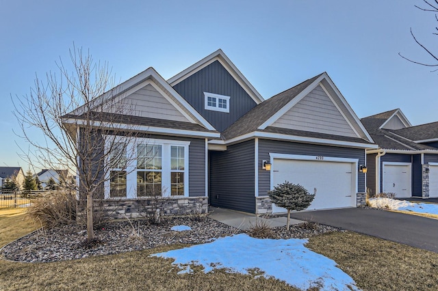 view of front of home featuring aphalt driveway, stone siding, board and batten siding, and an attached garage