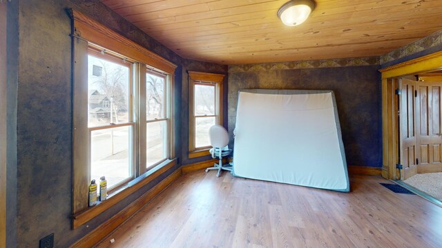 spare room featuring baseboards, wood finished floors, and wooden ceiling