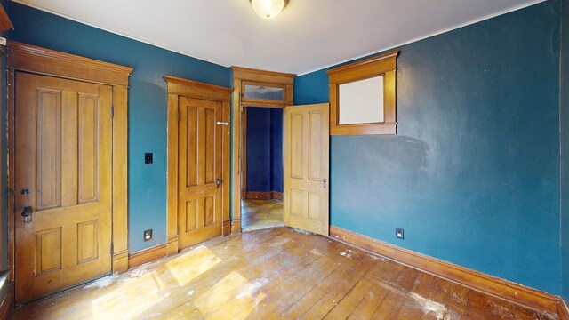 unfurnished bedroom with baseboards and light wood-type flooring