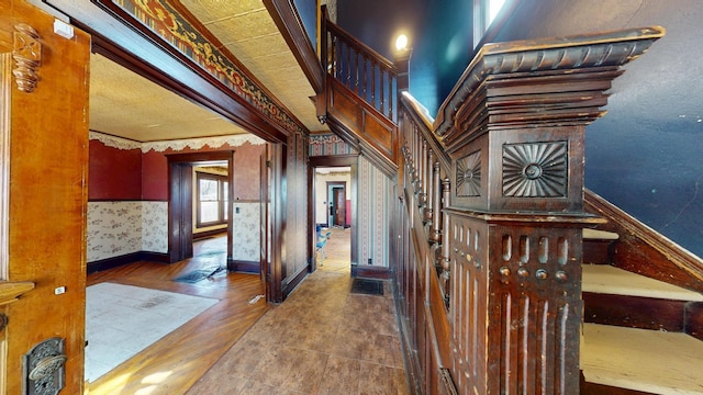 stairs featuring baseboards, wallpapered walls, and wood finished floors