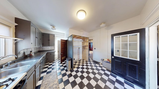 kitchen featuring gray cabinets, tasteful backsplash, dark countertops, and light floors