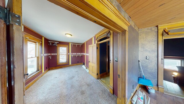 corridor with baseboards, carpet floors, and wood ceiling